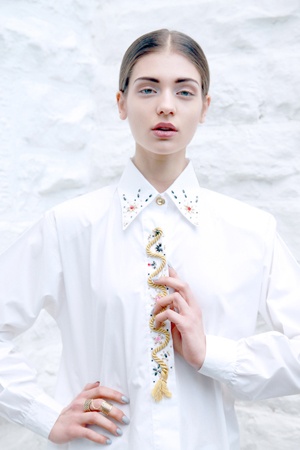 a young woman with her hair tied back in a white shirt and tie