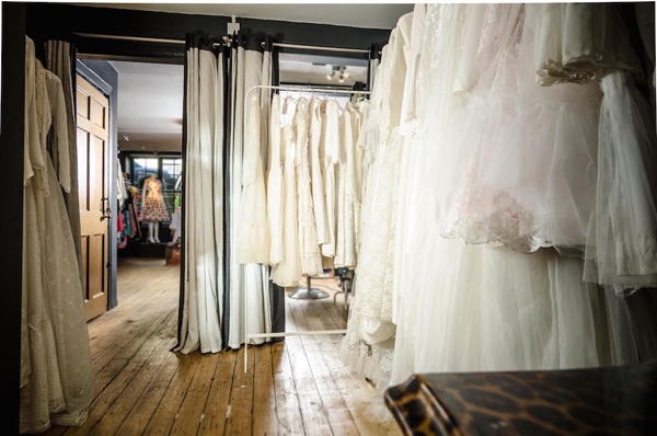 A backroom at Those Were The Days in Edinburgh with wooden floors filled with wedding dresses in the back of a vintage clothing shop