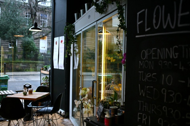 a table and chairs sit in the window of a coffee shop