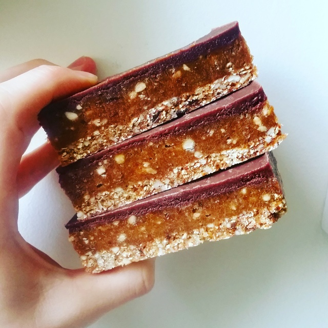 a hand holds three large chocolate biscuits