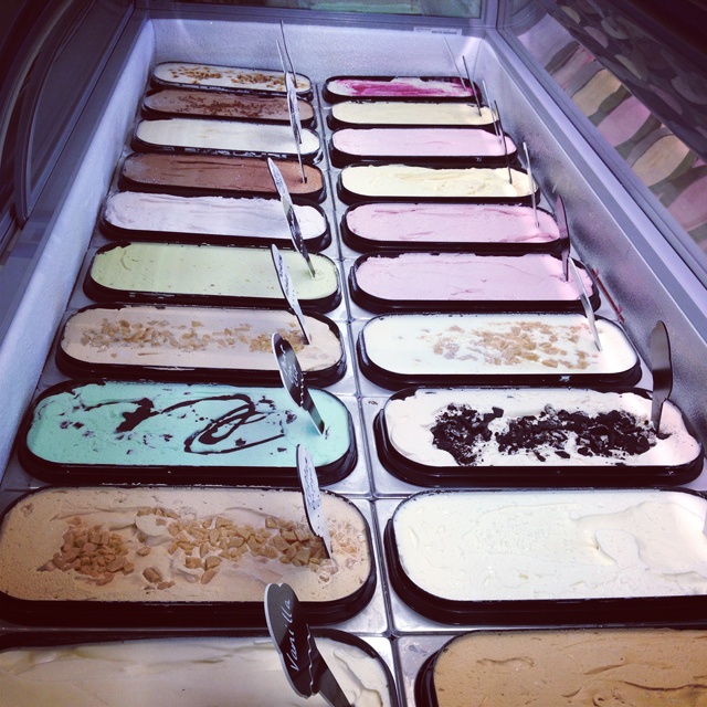 rows of different flavoured ice cream tubs in a long display freezer
