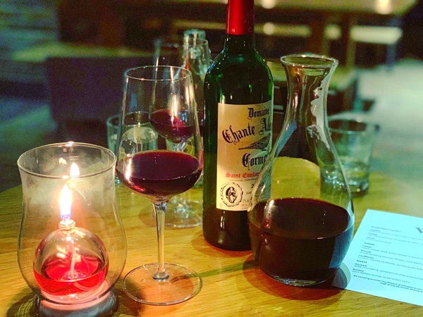candle wine bottle and glasses on a wooden table