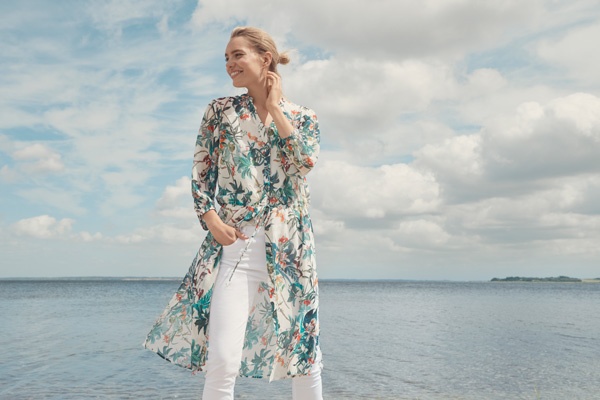 slim blonde female fashion model standing by the sea. Eden