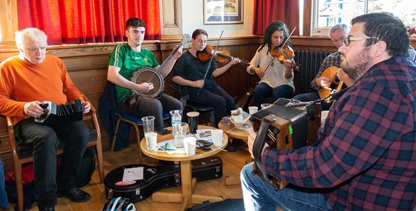 male and female traditional Irish musicians playing their instruments