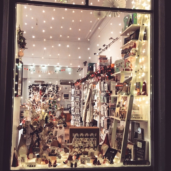 a gift shop Christmas window illuminated at night