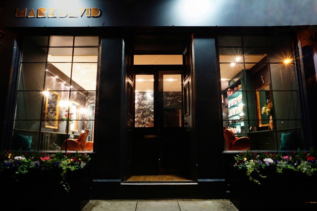 MarkDavid hair salon exterior with it's lights on at night