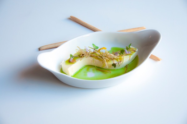 a small white boat shaped food plate and wooden chop sticks