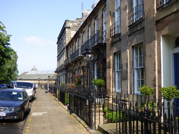 a row of terraced Georgian houses with black iron balconies and railings