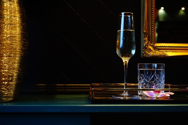 champagne glass on a shelf by a gold mirror
