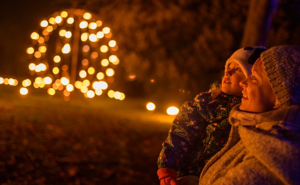 mother and child all wrapped up in warm clothes outside at a night time Christmas event