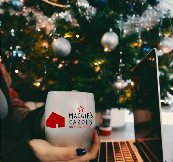 woman drinking coffee by a Christmas tree