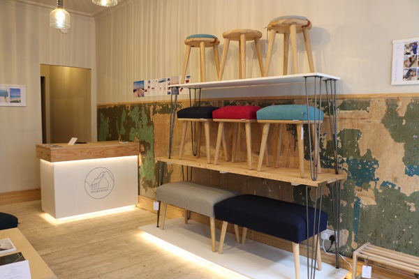 row of wooden stools on shelves in a shop