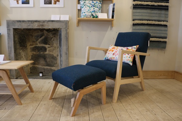 natural wooden blue upholstered chair and foot stool on a wooden floor