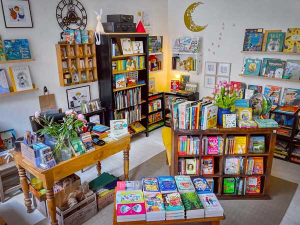 the interior of Ginger and Pickles bookshop with shelves, bookcases and display tables full of books