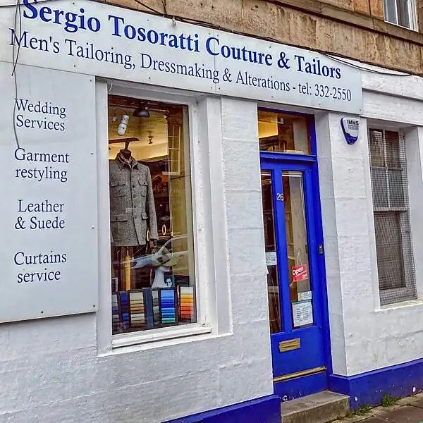 A white facade with a blue door of Sergio Tosoratti Couture and Tailors in Stockbridge, Edinburgh