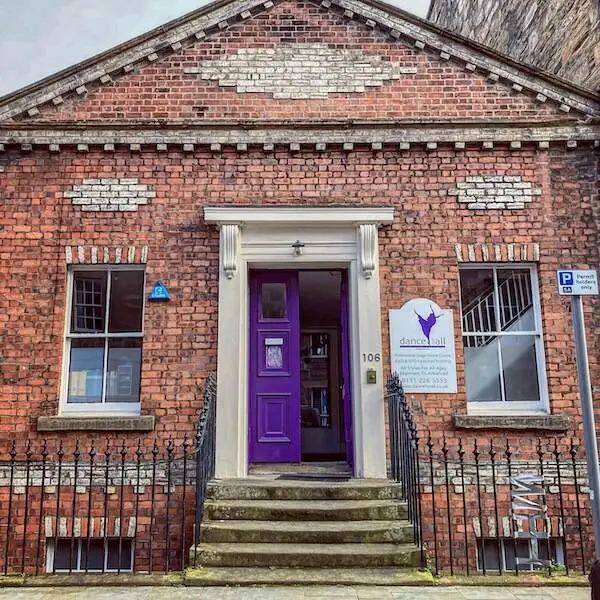 the red brick facade and purple doorway of Dance for All studios on St Stephen Street in Stockbridge, Edinburgh
