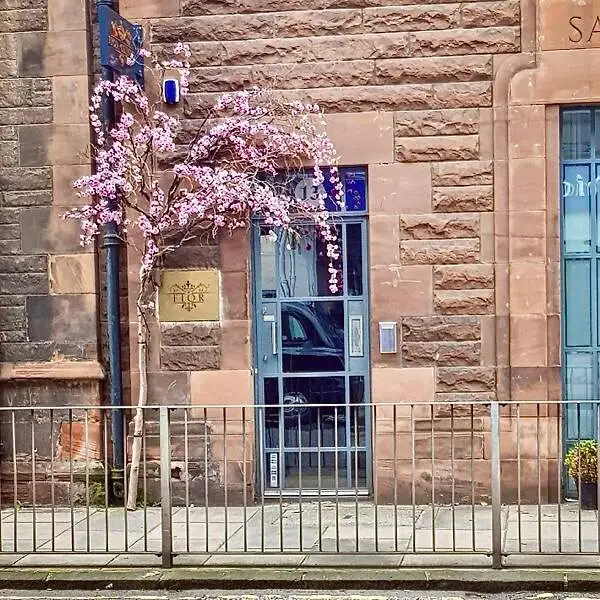 Pink Cherry Blossom adornes the doorway of a red sandstone building at Fior Health and Beauty in Stockbridge, Edinburgh